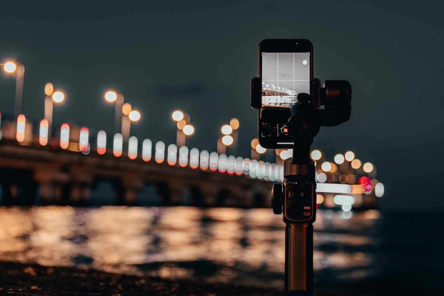 Viedtālrunis uzstādīts uz stabilizatora statīva Viedtālrunis ir uzstādīts uz stabilizējoša statīva, lai izvairītos no izplūdušiem fotoattēliem un panāktu asumu ilgstošas ekspozīcijas kadros naktī.