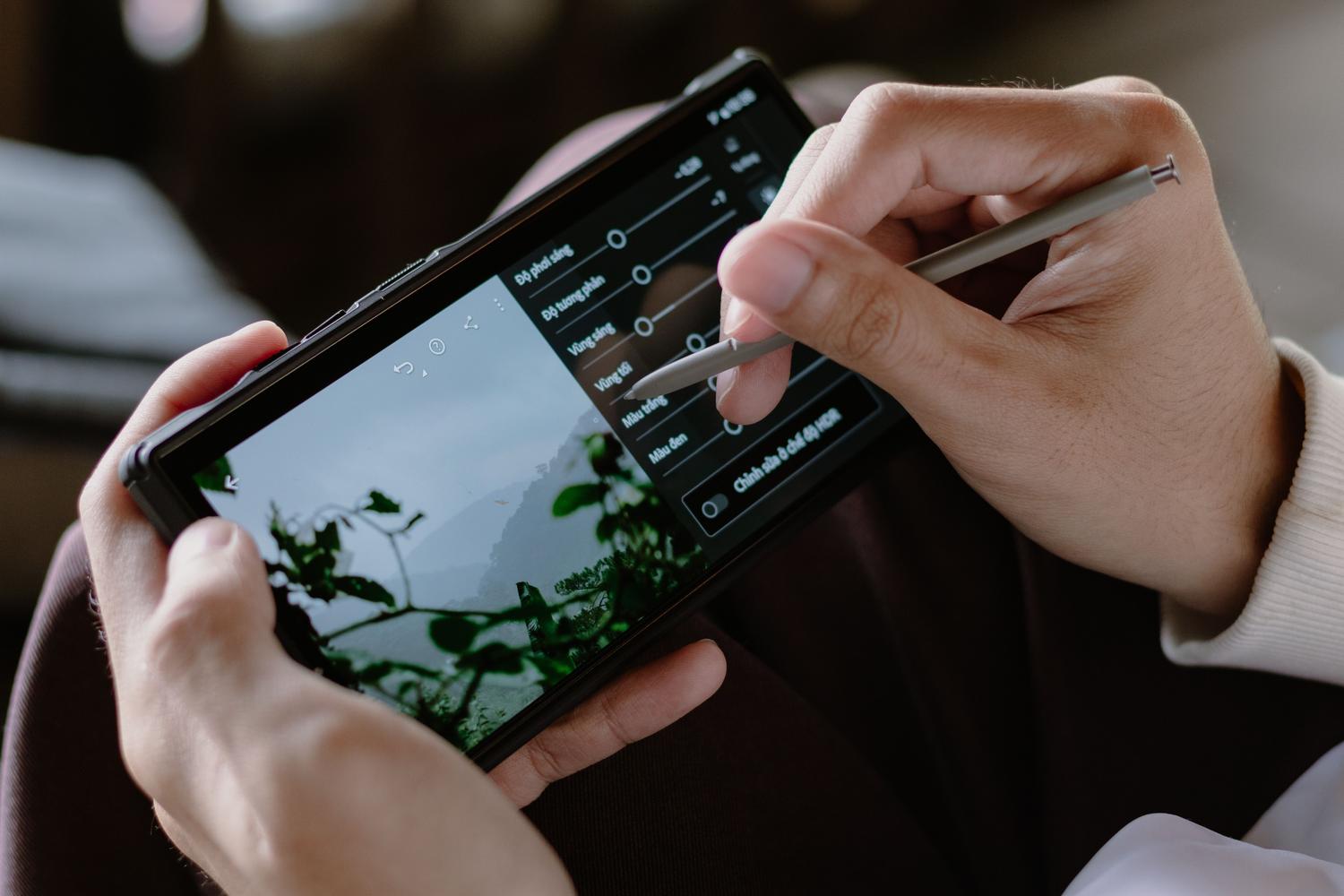 Persona, kas rediģē fotoattēlu savā viedtālrunī, lai pielāgotu definīciju Persona, kas savā viedtālrunī rediģē fotoattēlu, lai pielāgotu izšķirtspēju un samazinātu digitālo troksni, izmantojot pēcapstrādes lietojumprogrammas.