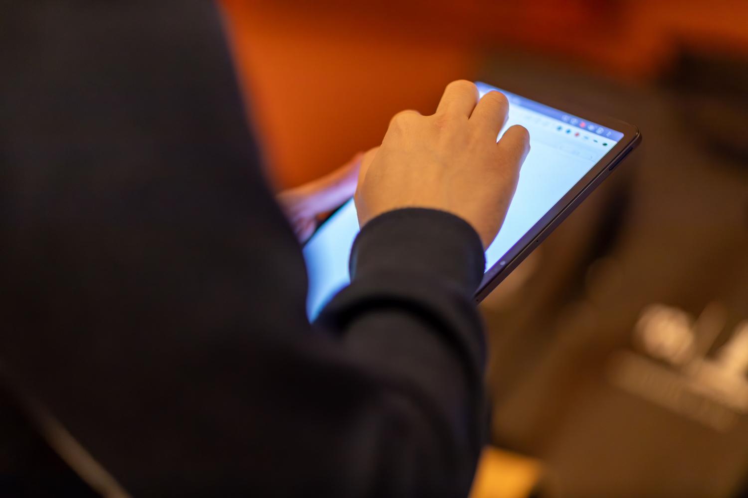 Persona, kas izmanto iPad, lai lasītu WhatsApp tērzēšanas sarunas, kuru dzēšana vēl nav sinhronizēta