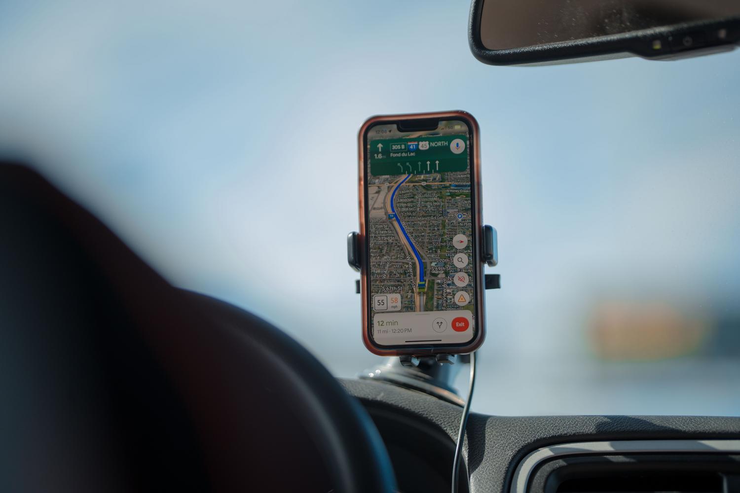 Viedtālrunis ar GPS navigāciju, kas uzstādīts automašīnā saulainā dienā Viedtālrunis ar GPS navigāciju, kas uzstādīts automašīnā saulainā dienā