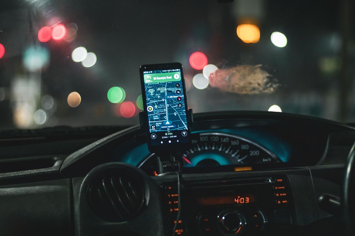 iPhone ar GPS navigācijas lietotni automašīnā naktī iPhone ar GPS navigācijas lietotni automašīnā naktī