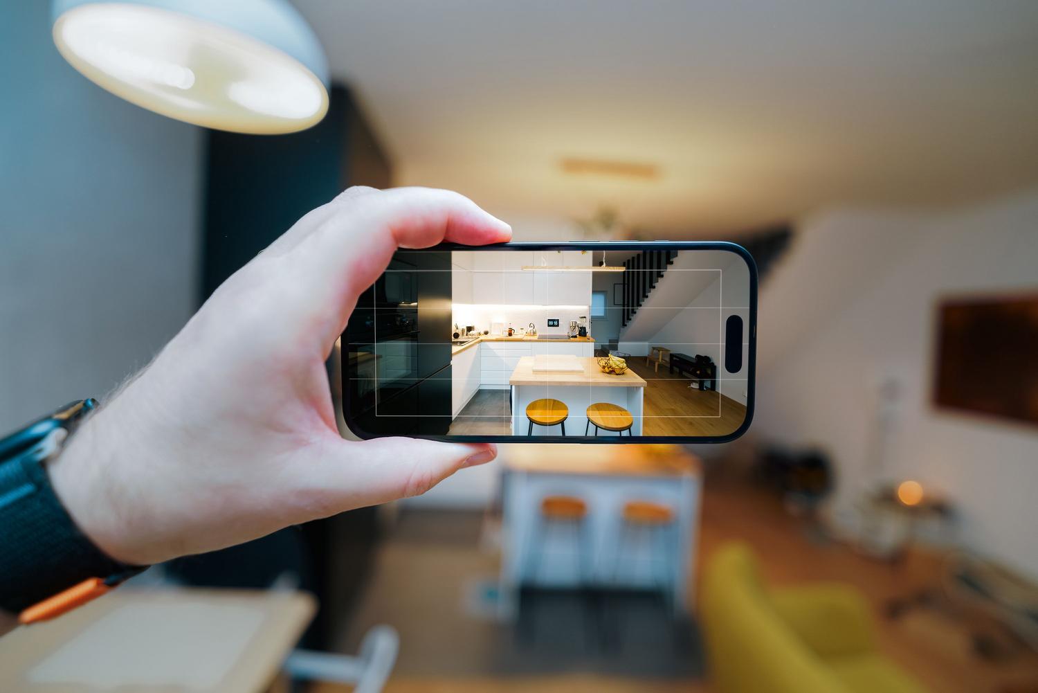 Izmantojot iPhone, lai fiksētu un izmērītu modernas, minimālistiskas virtuves izmērus.