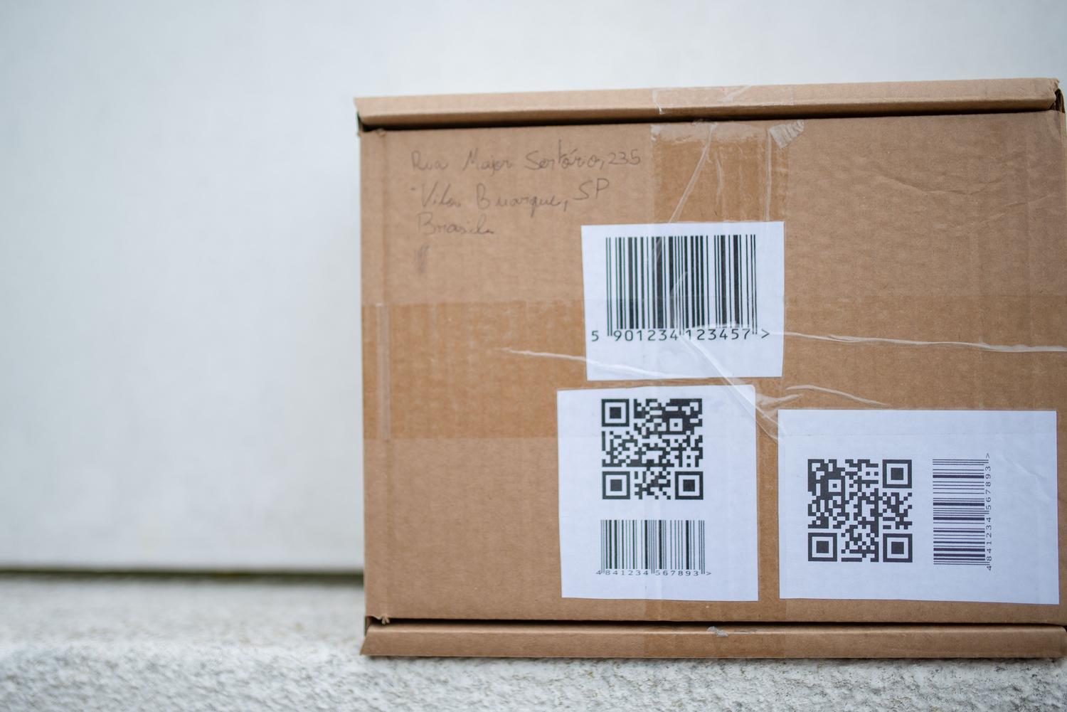 Sīkāka informācija par piegādes etiķetēm un QR kodiem uz kartona kastes, kas ir būtiska paku izsekošanai. Sīkāka informācija par piegādes etiķetēm un QR kodiem uz kartona kastes, kas ir būtiska paku izsekošanai.