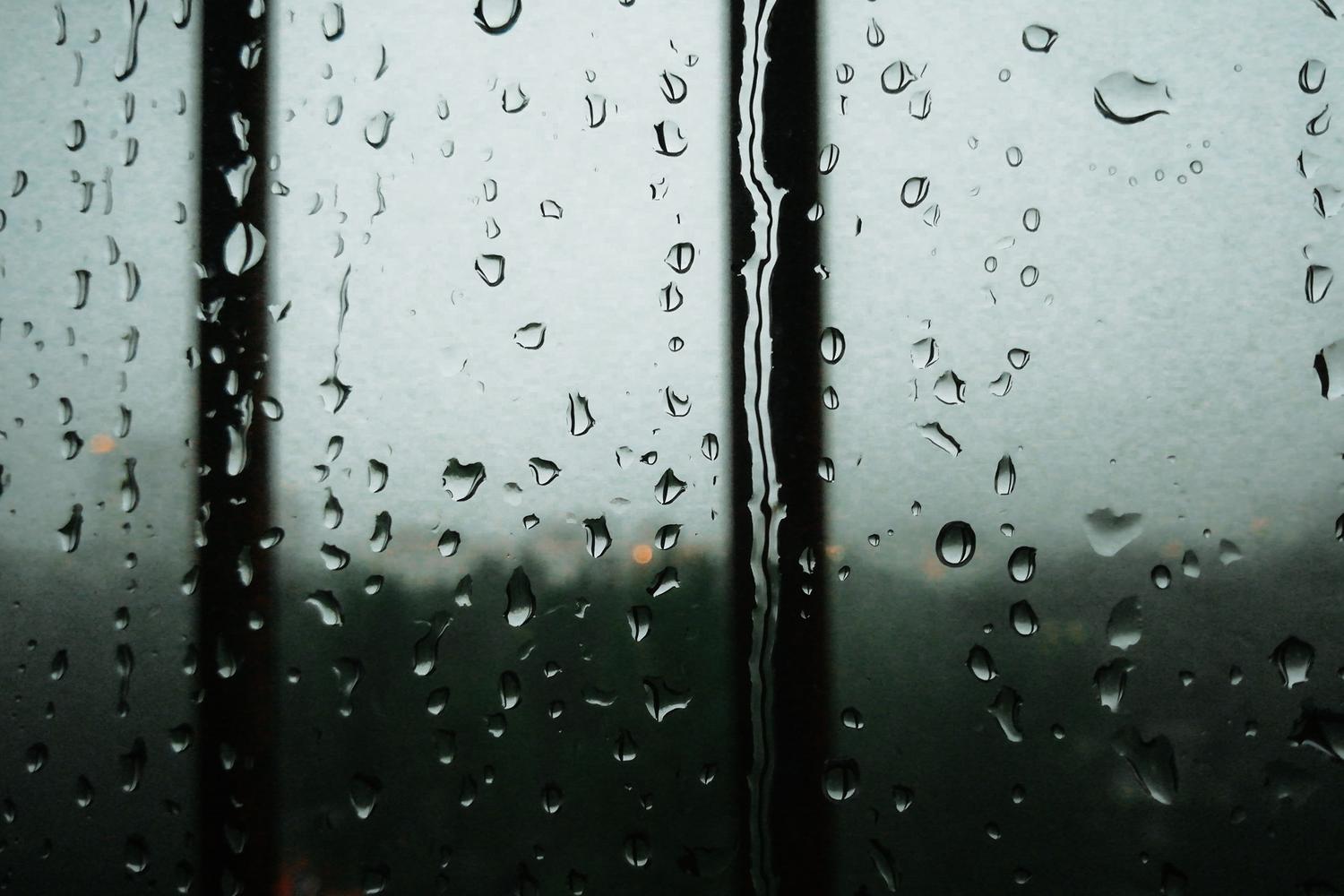 Tuvplāns lietus lāsēm uz loga, kas izraisa iPhone lietus fona skaņu atmosfēru.