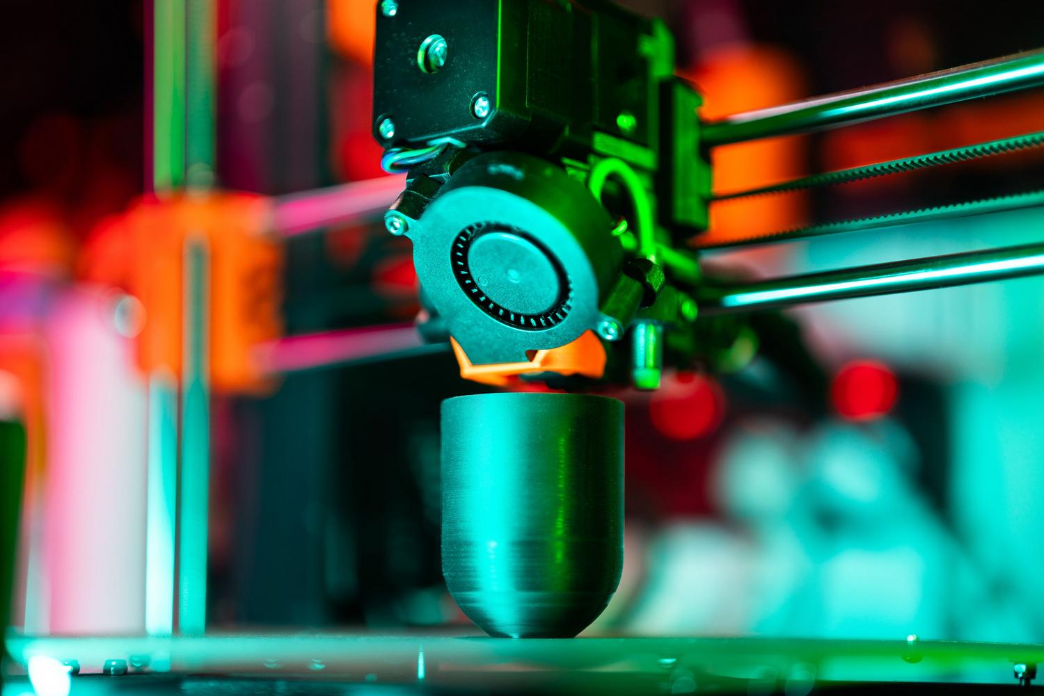 3D printera tuvplāns, kas veido objektu, ilustrē digitālā modeļa materializāciju.