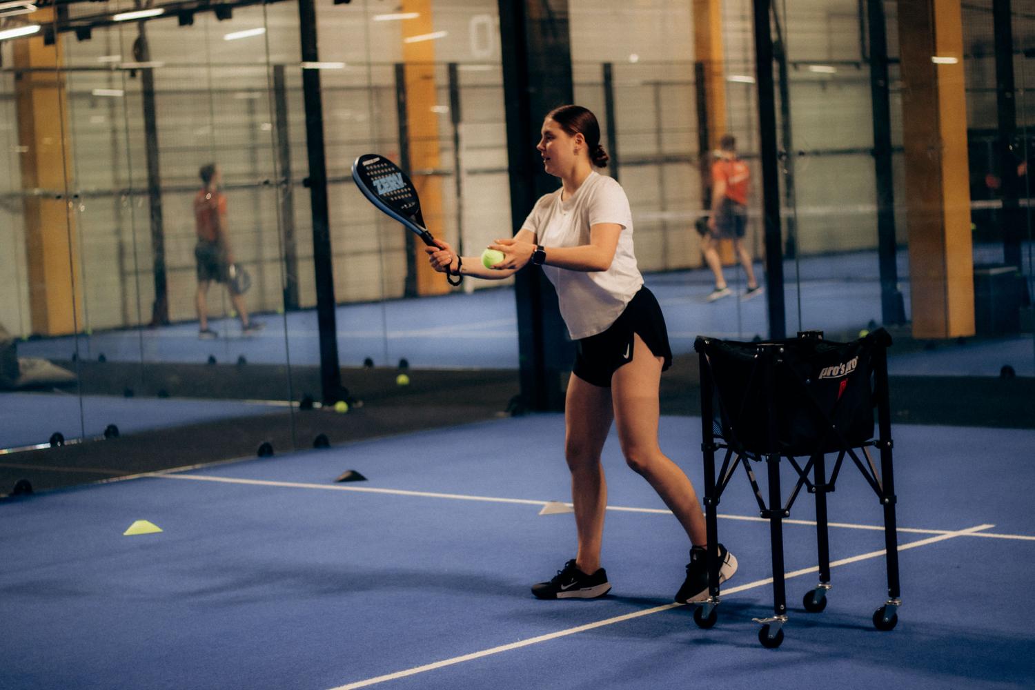 Padel spēlētājs gatavojas kalpot iekštelpu laukumā. Padel spēlētājs gatavojas kalpot iekštelpu laukumā.